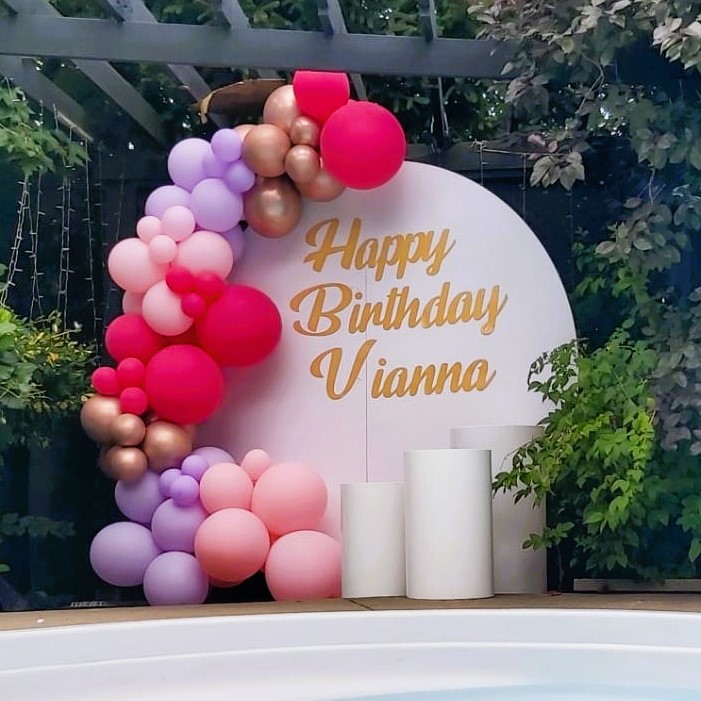a birthday backdrop and balloon decor with 3 plinths